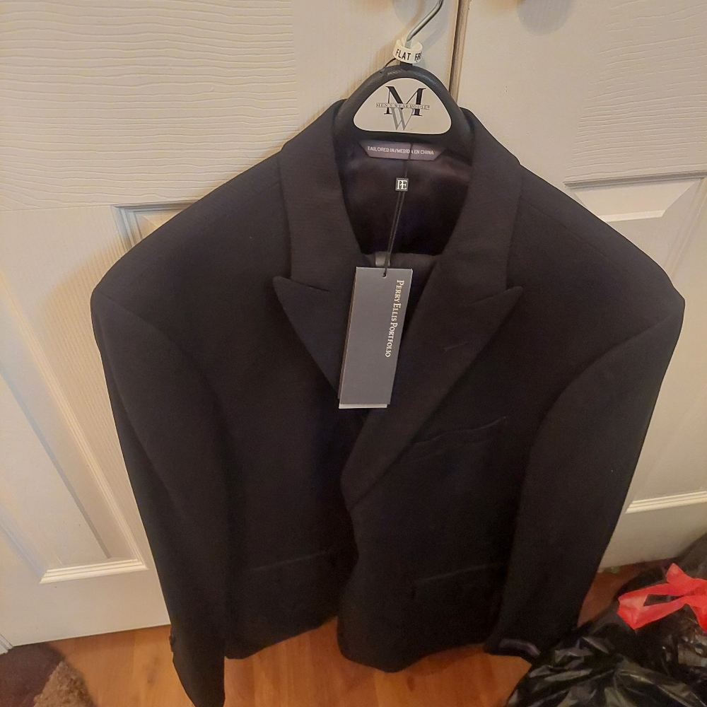 100% wool. Classic black perry ellis suit. Never worn. Jacket and slacks.